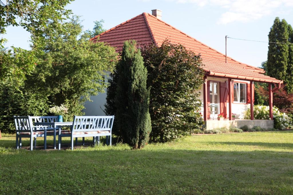 Deux bancs dans l'herbe devant une maison dans l'établissement Nagymajor Birding Lodge, à Tiszacsege