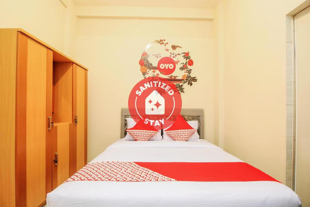 a bedroom with a bed with a red sign on it at SUPER OYO 168 K-15 Residence in Kedongdong