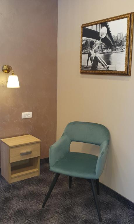a green chair in a room with a table and a mirror at Skadarlija Suites in Belgrade