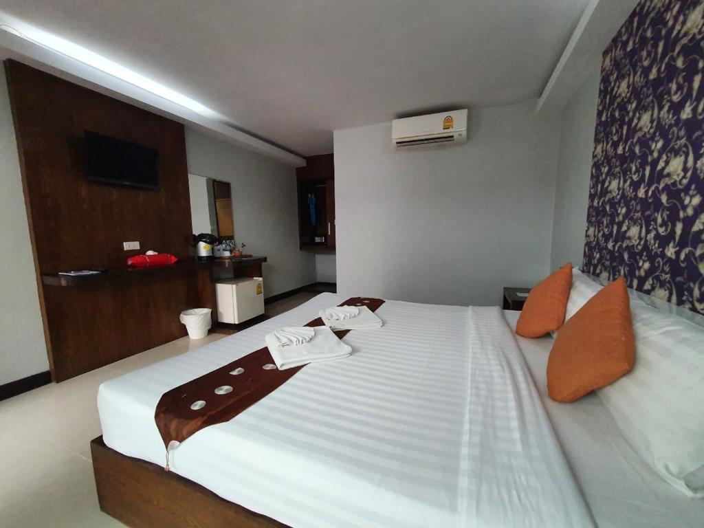 
a hotel room with a bed and a dresser at Ibiza House Phi Phi in Phi Phi Islands

