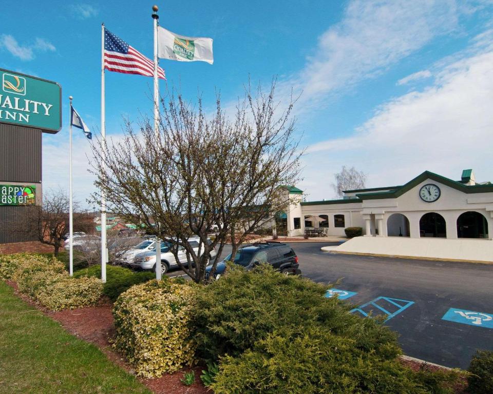 Zwei Flaggen fliegen vor einem Gebäude in der Unterkunft Quality Inn Beckley in Beckley