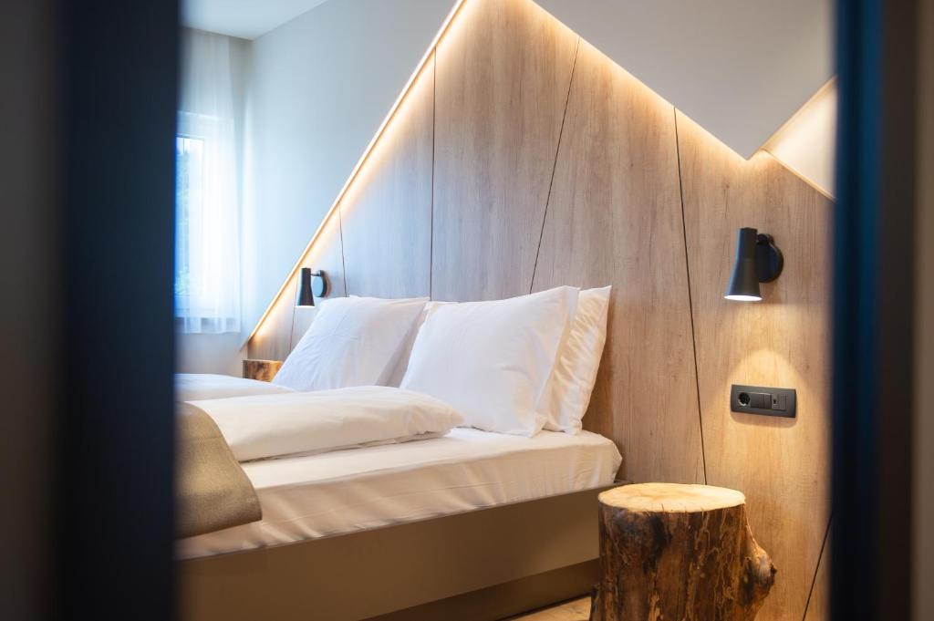 sypialnia z łóżkiem z drewnianym zagłówkiem w obiekcie Penzion Repanšek w mieście Radomlje