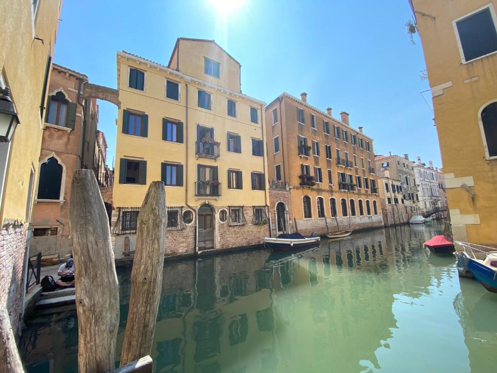 a canal with buildings and boats in the water at Suite House new apartments canal view Venice island in Venice