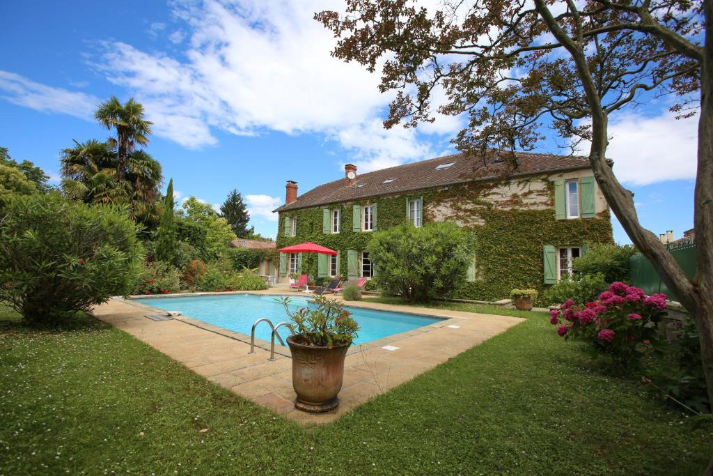 une maison avec une piscine dans la cour dans l'établissement Chambres d'Hôtes Le Mas, à Aire-sur-lʼAdour