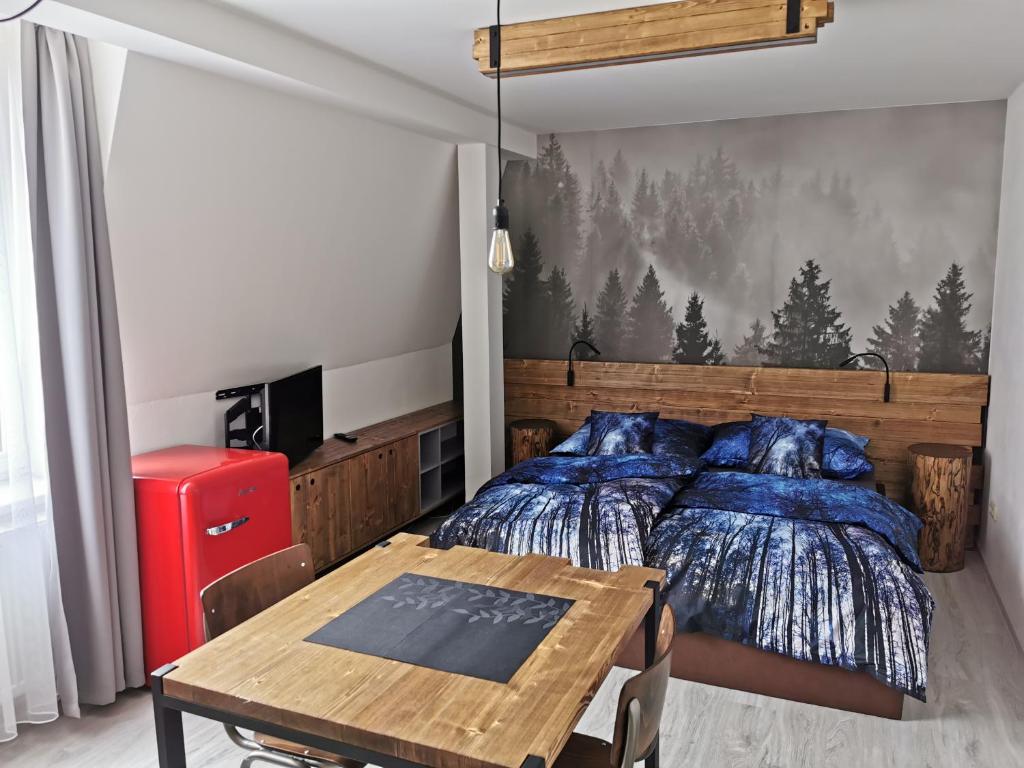 sypialnia z łóżkiem i drewnianym stołem w obiekcie Luxusní apartmány Soběslav w mieście Soběslav