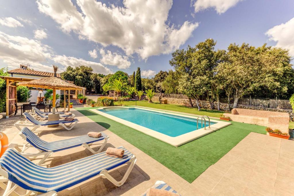 una piscina con 2 tumbonas y un patio en Villa Salve, en Pollensa