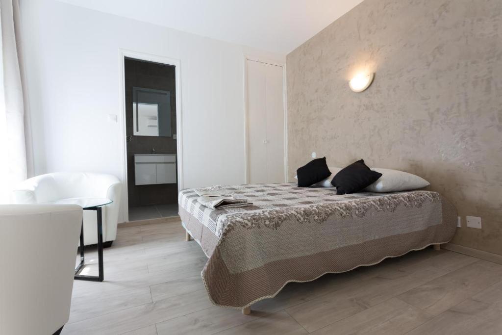 sypialnia z łóżkiem w białym pokoju w obiekcie Hotel Alizéa w Awinionie