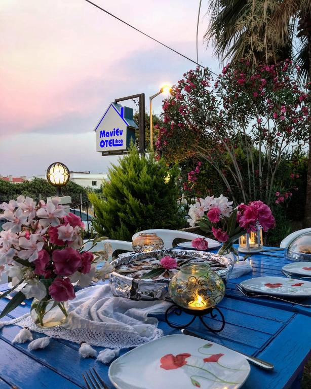 a blue table with plates and flowers on it at Maviev Otel in Çeşme