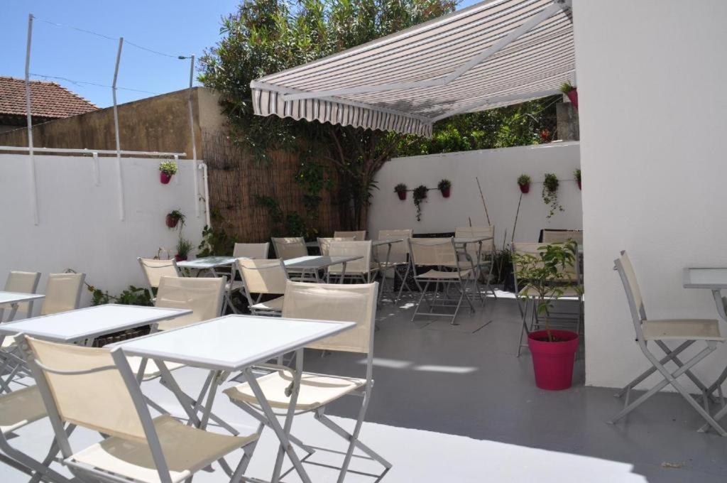 a patio area with tables, chairs and umbrellas at Hôtel Saint George in Avignon