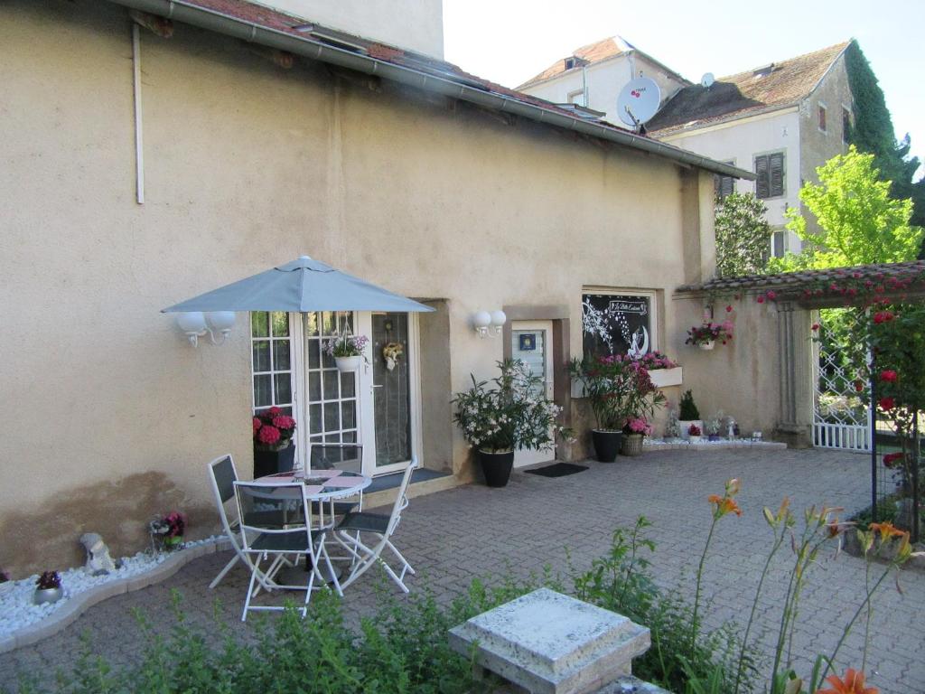 a patio with a table and an umbrella at La belle endormie - appartement B in Fénétrange