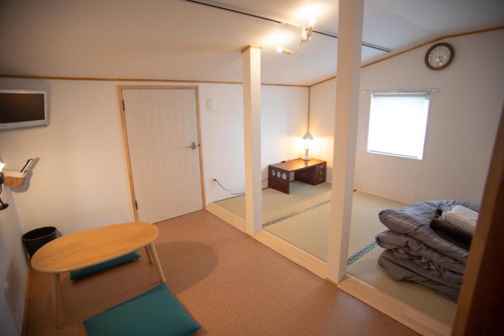 um quarto com um espelho, uma mesa e um relógio em Otaru Village - Vacation STAY 84438 em Otaru
