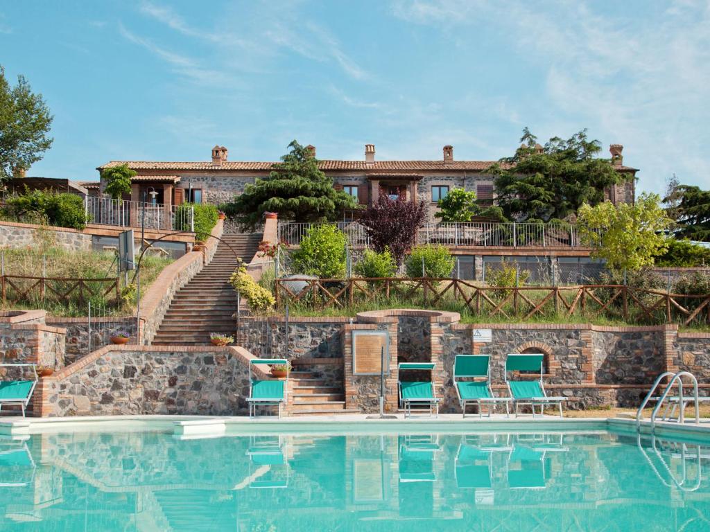 uma piscina com cadeiras e escadas ao lado de uma casa em Apartment Pomele-2 by Interhome em San Lorenzo Nuovo