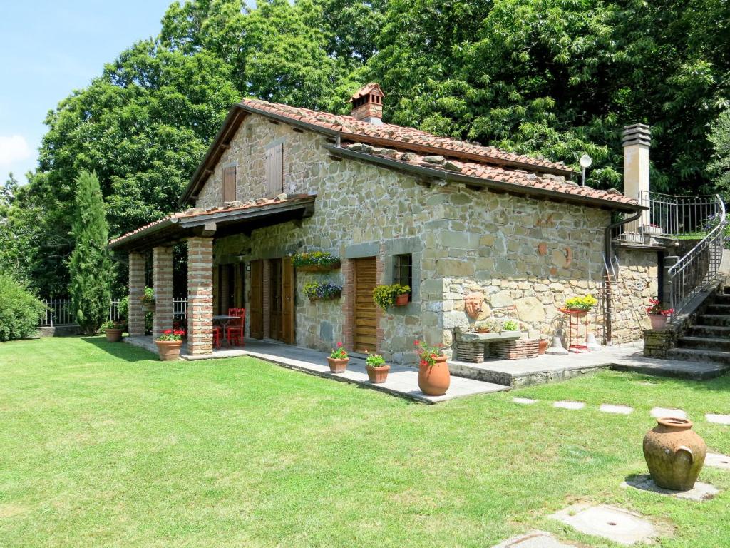 una pequeña casa de piedra con un patio de césped en Holiday Home Belvedere - BLU100 by Interhome, en Bagni di Lucca