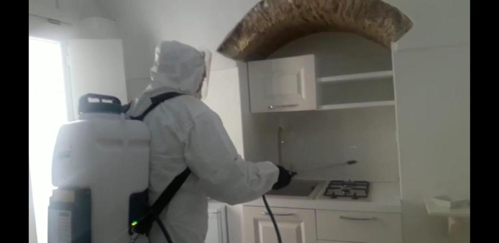 a man in a kitchen wearing ansicsnsicsnsicsnsicsnsics at Suite Pitagora in Bernalda