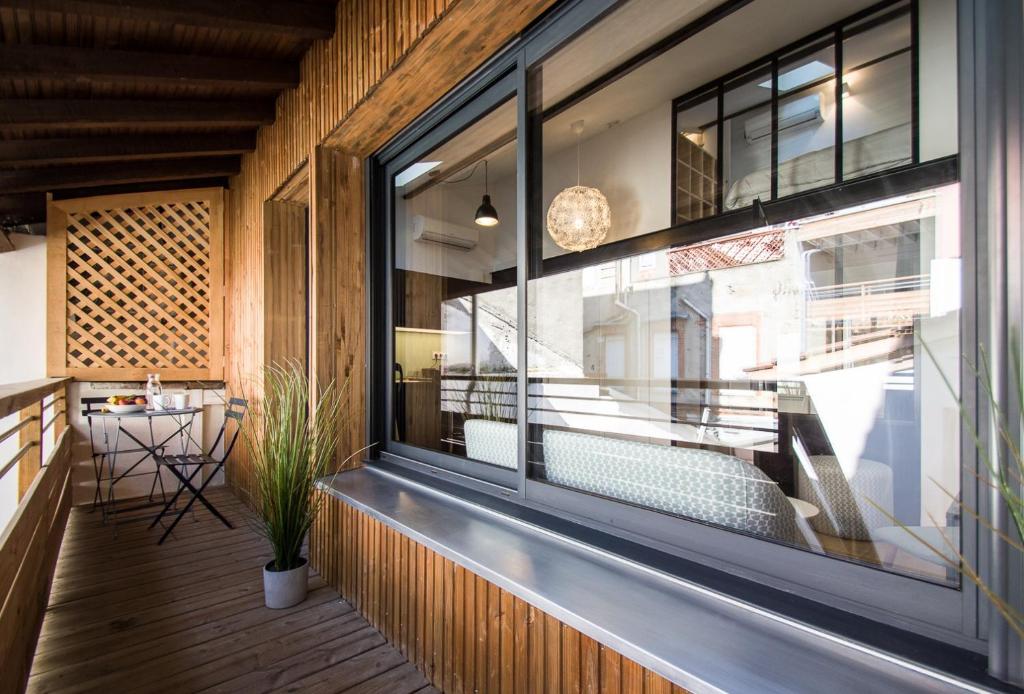 - une vue depuis le balcon d'un restaurant doté d'une grande fenêtre dans l'établissement LE DIEBOLD - Appartement 2 chambres climatisé, à Toulouse