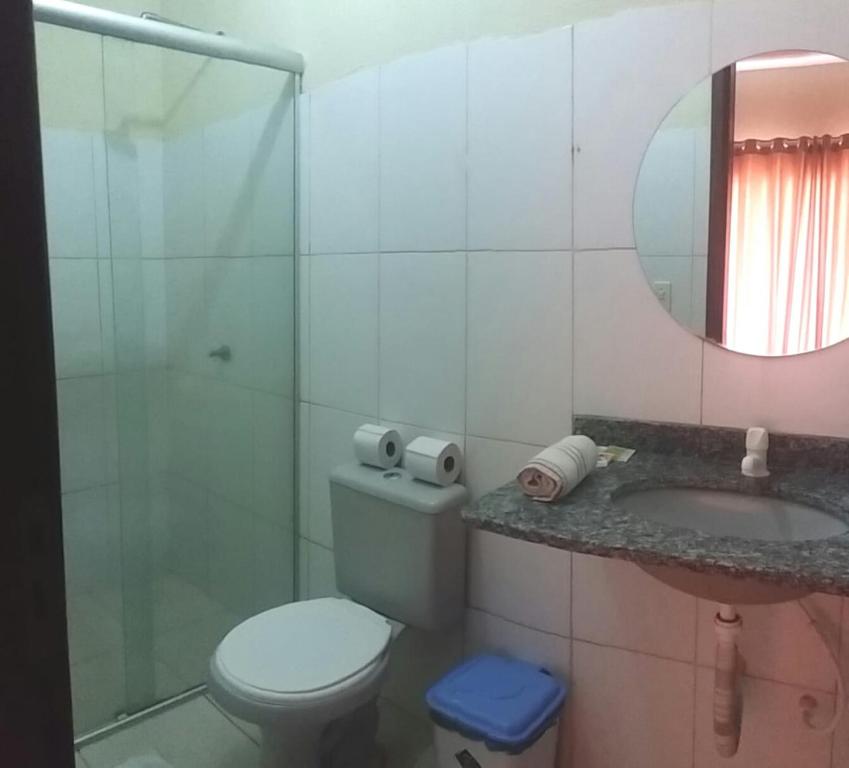 a bathroom with a toilet and a sink and a mirror at Hotel Brisas in Salinópolis