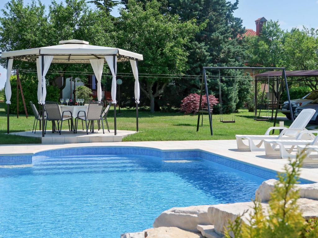 a swimming pool with a gazebo and a table and chairs at Holiday Home Andrea - LBN415 by Interhome in Labin