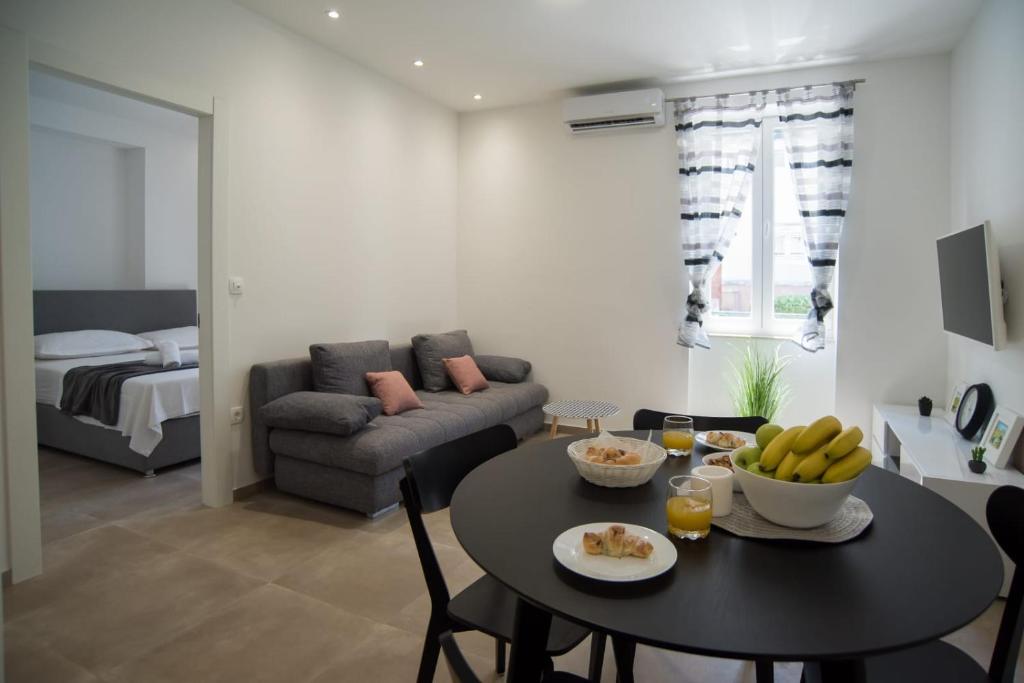 uma sala de estar com uma mesa e um sofá em Ita&Toni apartment em Split