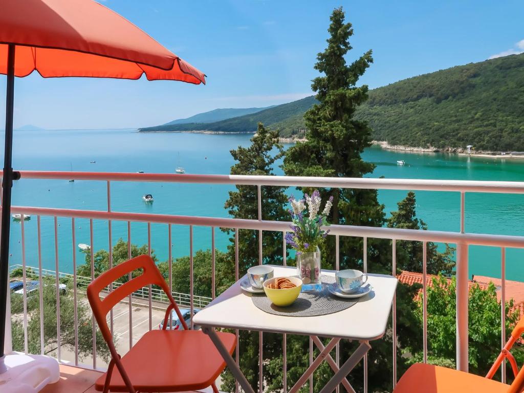 a table on a balcony with a view of the water at Apartment Boris - RAC160 by Interhome in Raša