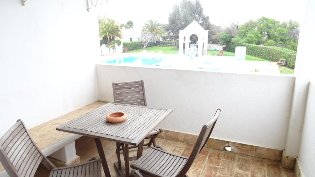 a balcony with a table and chairs and a pool at Quinta Velha Village - Apart. T1 in Cabanas de Tavira