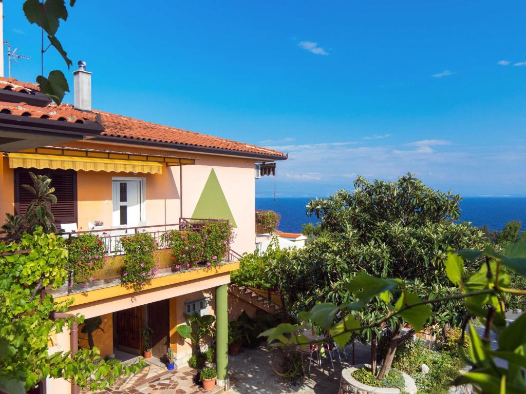 a house with a balcony with the ocean in the background at Apartment Sandalj-2 by Interhome in Kraj