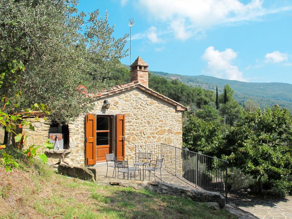 una piccola casa in pietra con tavolo e sedie di Holiday Home Bramasole by Interhome a Cortona