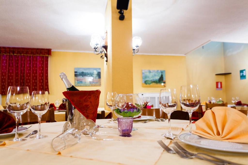 a table with glasses and a bottle of wine on it at Hotel Biancaneve in Sestriere