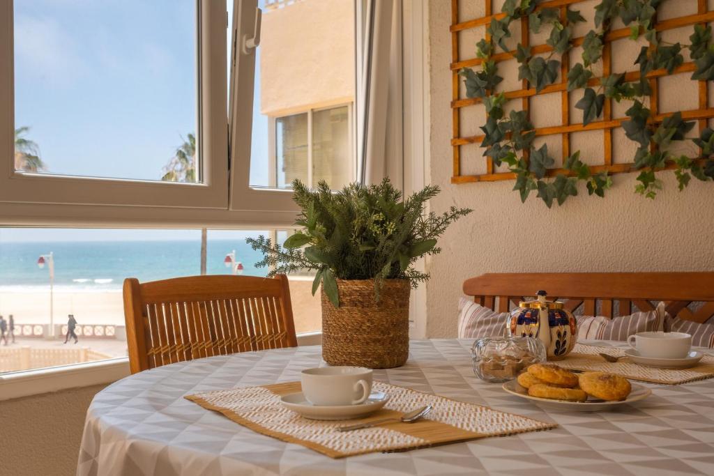 - une table à manger avec vue sur la plage dans l'établissement BLUE Atlantic Family Home by Cadiz4Rentals, à Cadix