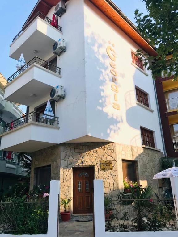 a white building with a door and a balcony at Джорджия in Kiten