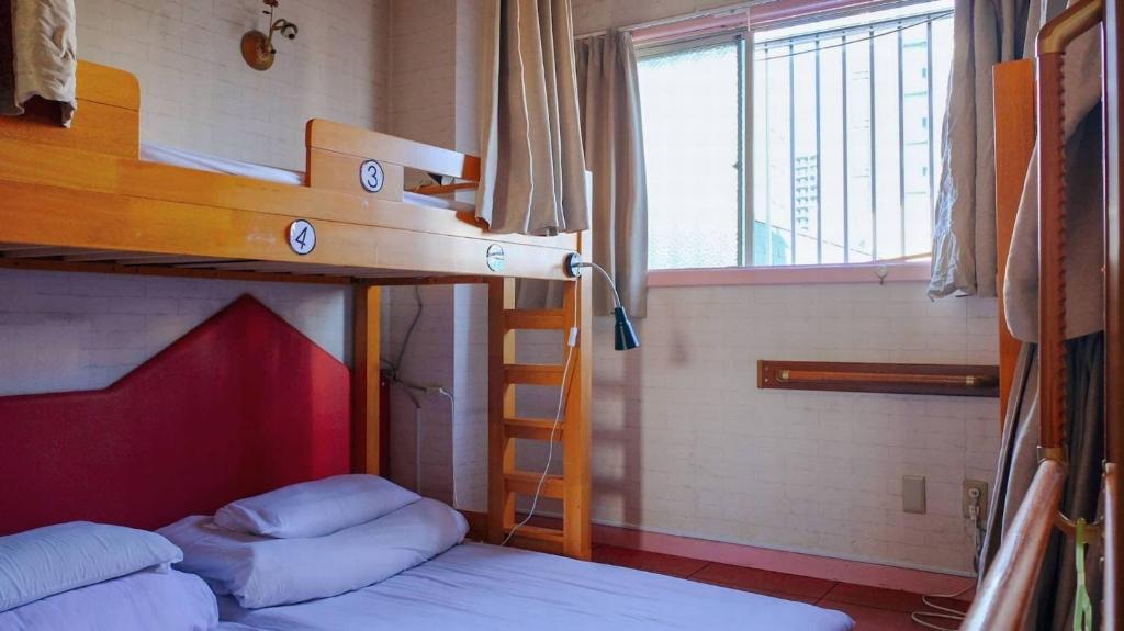 a bedroom with two bunk beds and a ladder at City view guesthouse Private room - Vacation STAY 85052 in Osaka