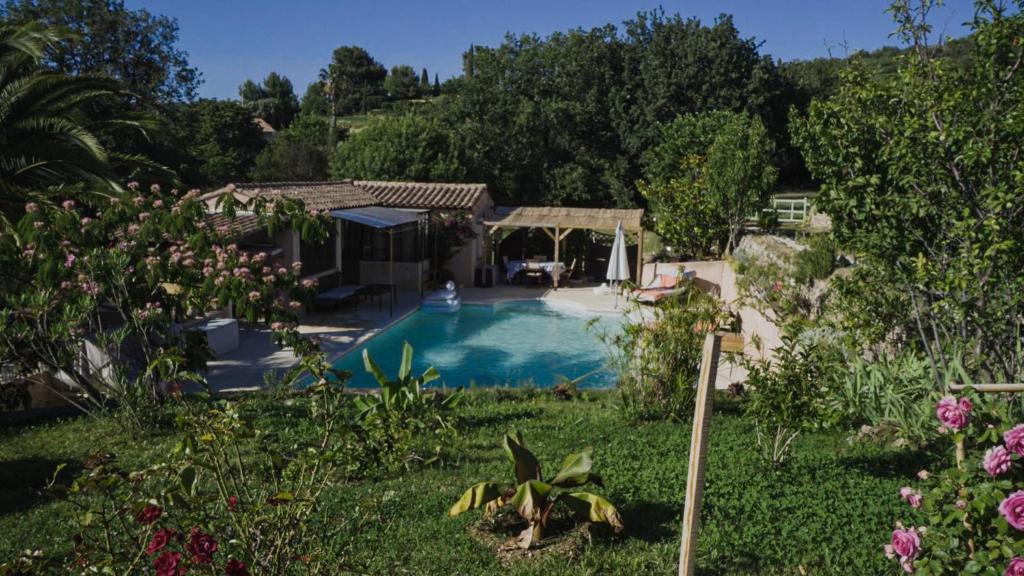 a house with a swimming pool in a garden at une petite maison entre vignes et mer in Saint-Côme