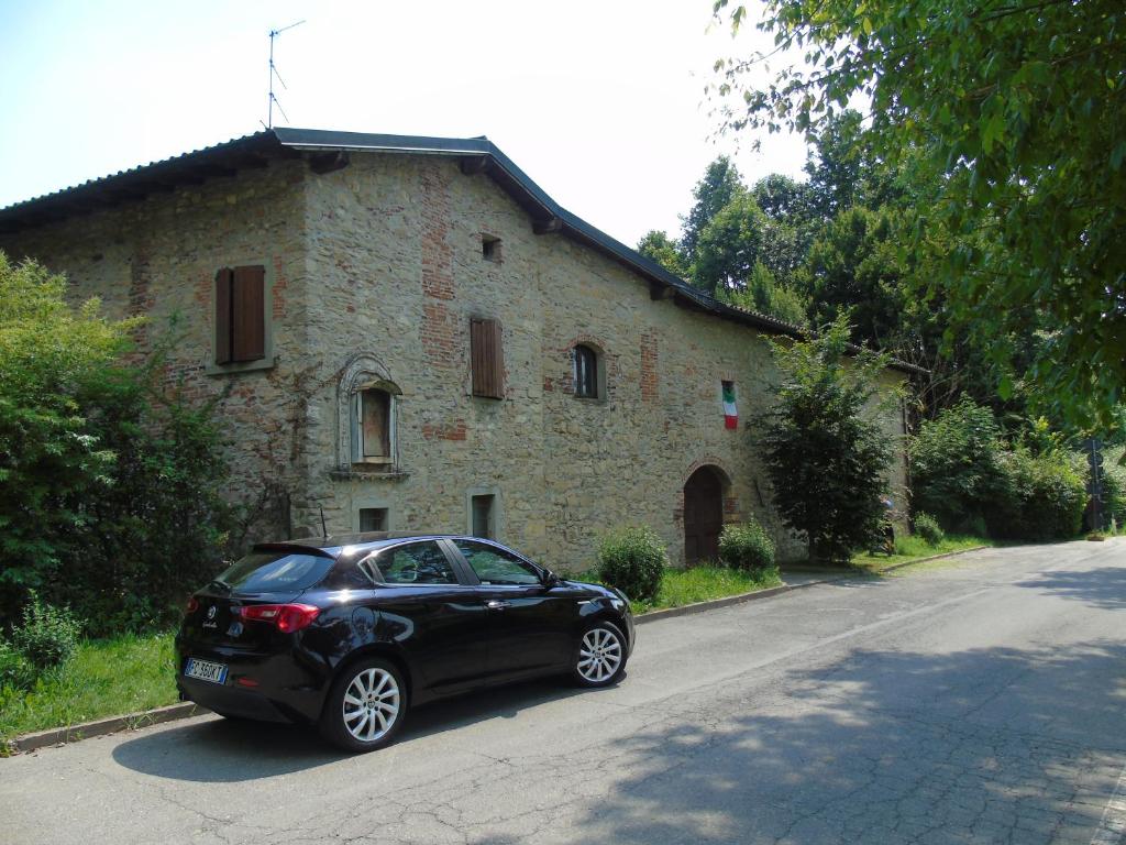 een zwarte auto geparkeerd voor een stenen gebouw bij Cascina Cavalli Astino in Bergamo
