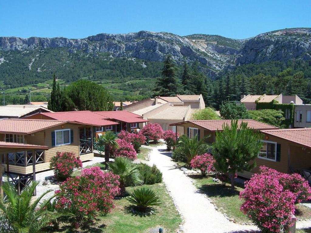 Une rangée de maisons avec des fleurs et des montagnes en arrière-plan dans l'établissement RESIDENCE TORRE DEL FAR, à Tautavel