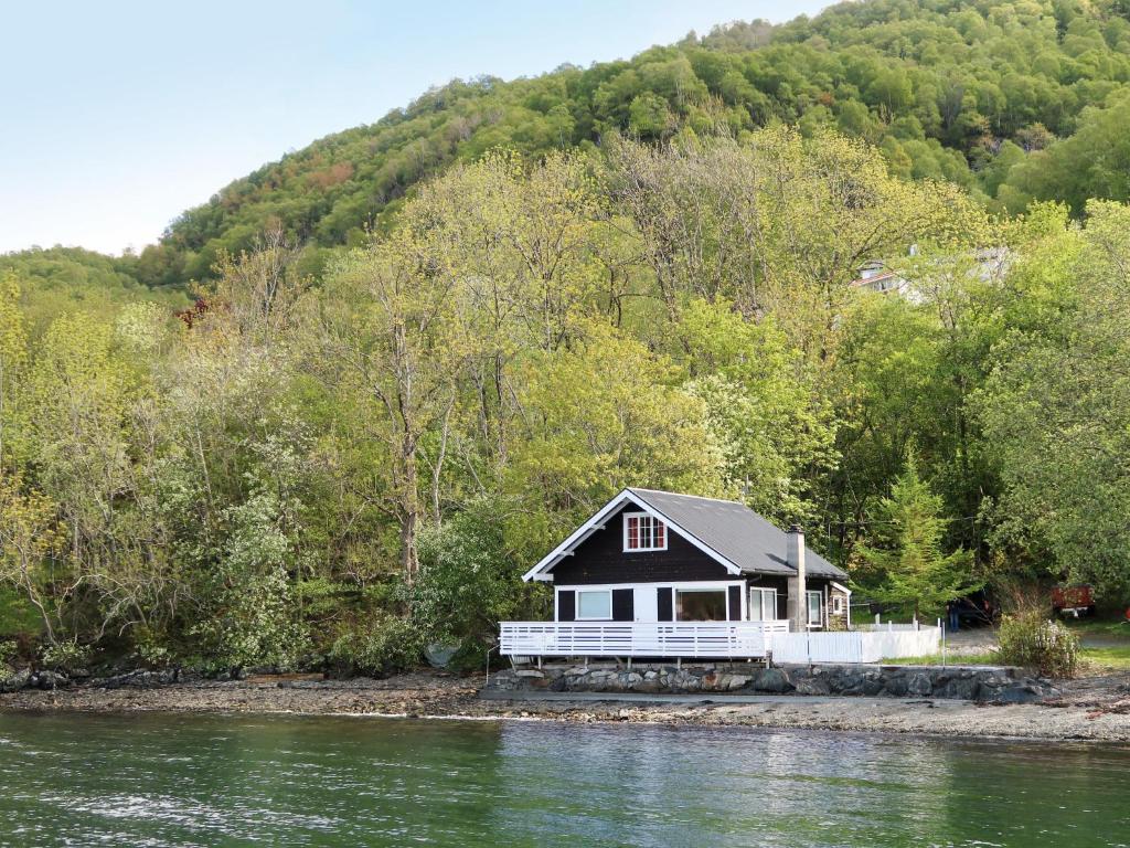 a small house on the shore of a river at Holiday Home Jokobu - FJH087 by Interhome in Skånevik