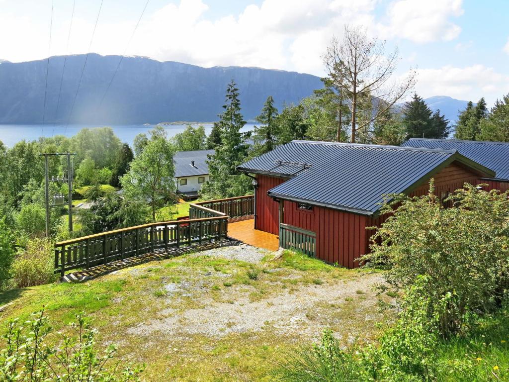 uma casa vermelha com uma varanda e uma casa em Holiday Home Fjordperlen - FJS145 by Interhome em Sørbø