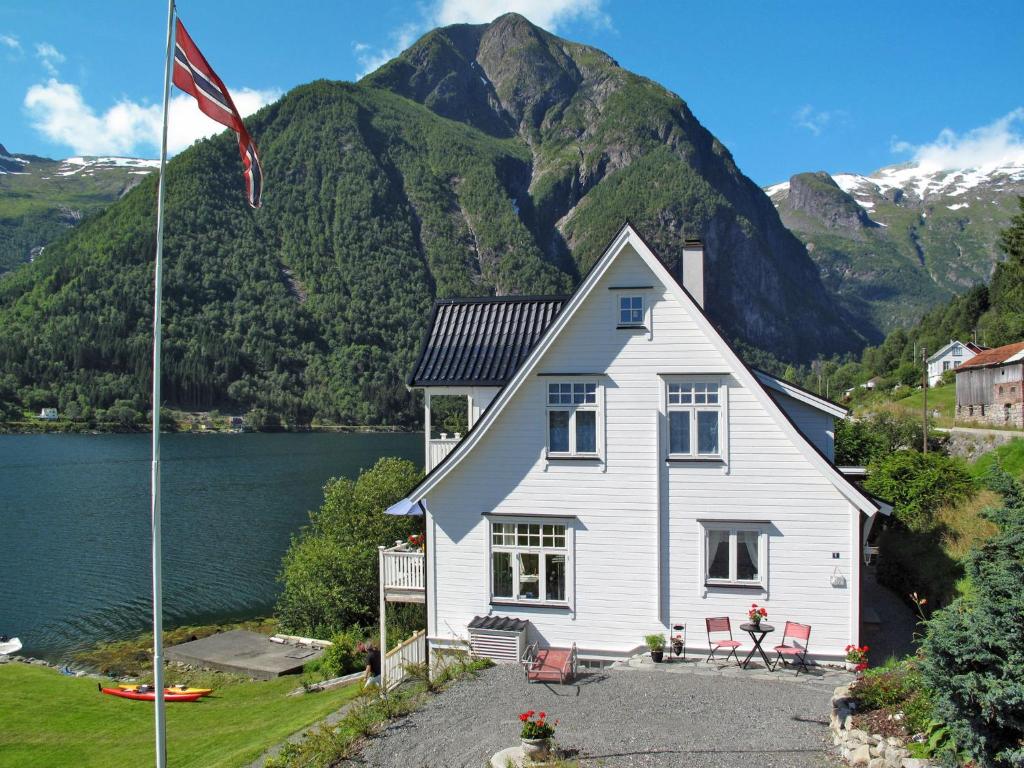 a house with a flag in front of a mountain at Chalet Villa Esefjord - FJS003 by Interhome in Balestrand