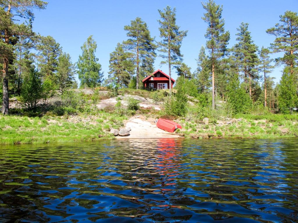 Mjåvatn的住宿－Chalet Saglia - SOO020 by Interhome，水体旁的山丘上的小屋