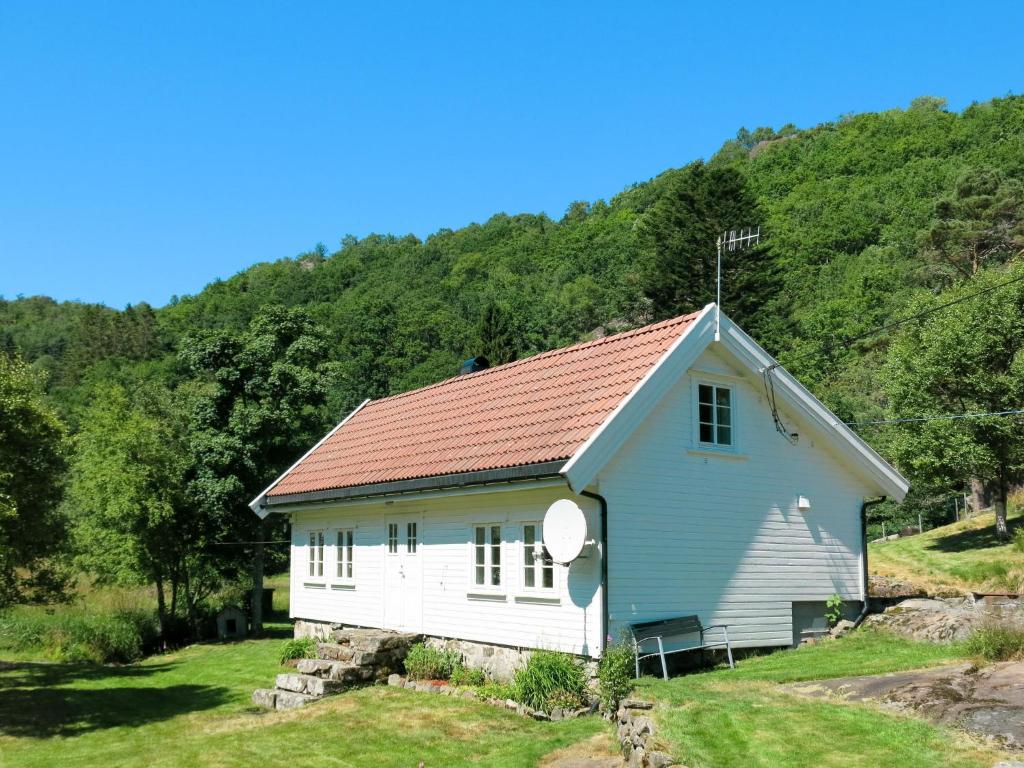 uma pequena casa branca com um telhado vermelho em Chalet Nedregård - SOW002 by Interhome em Farsund