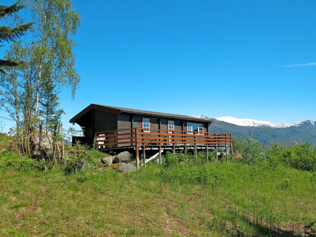 a house on a hill with mountains in the background at Chalet Haugly - FJS022 by Interhome in Balestrand