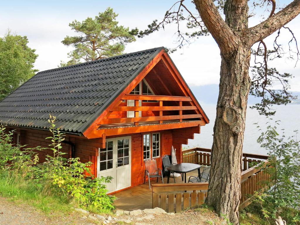 a log cabin with a porch and a tree at Holiday Home Maria - FJS114 by Interhome in Balestrand