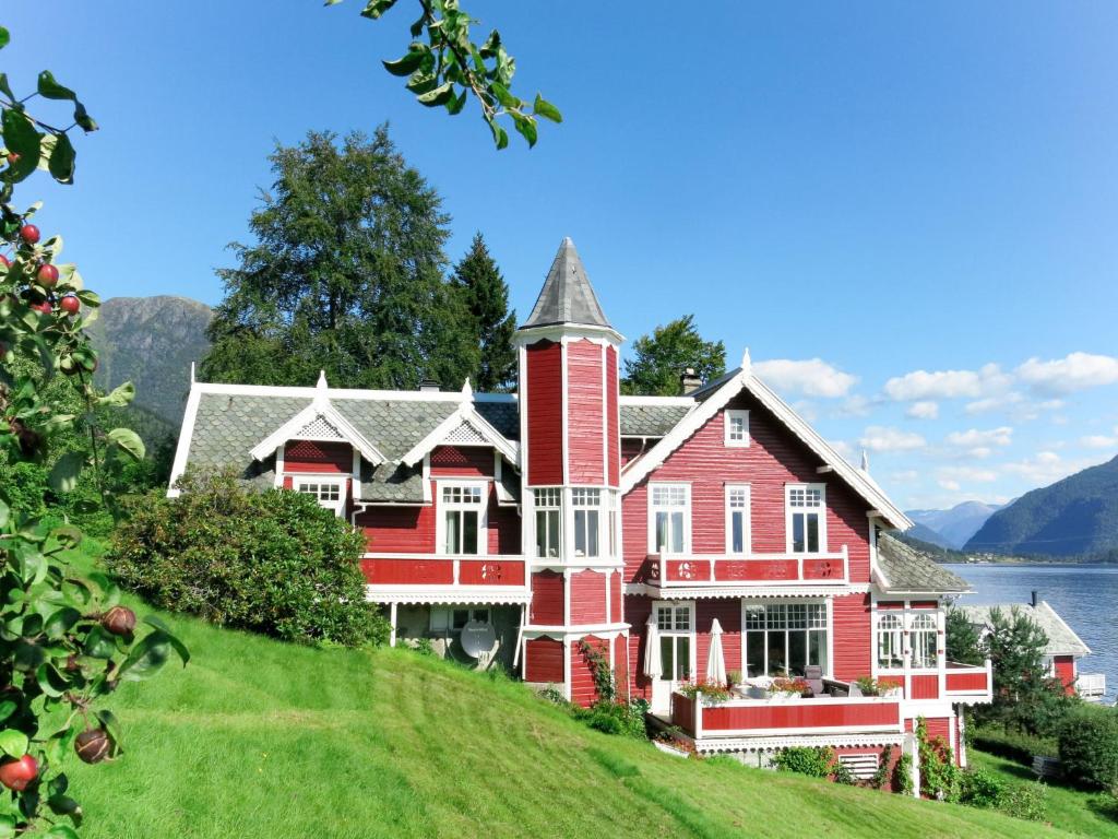 a large red house on top of a hill at Apartment Villa Lorna - FJS026 in Balestrand
