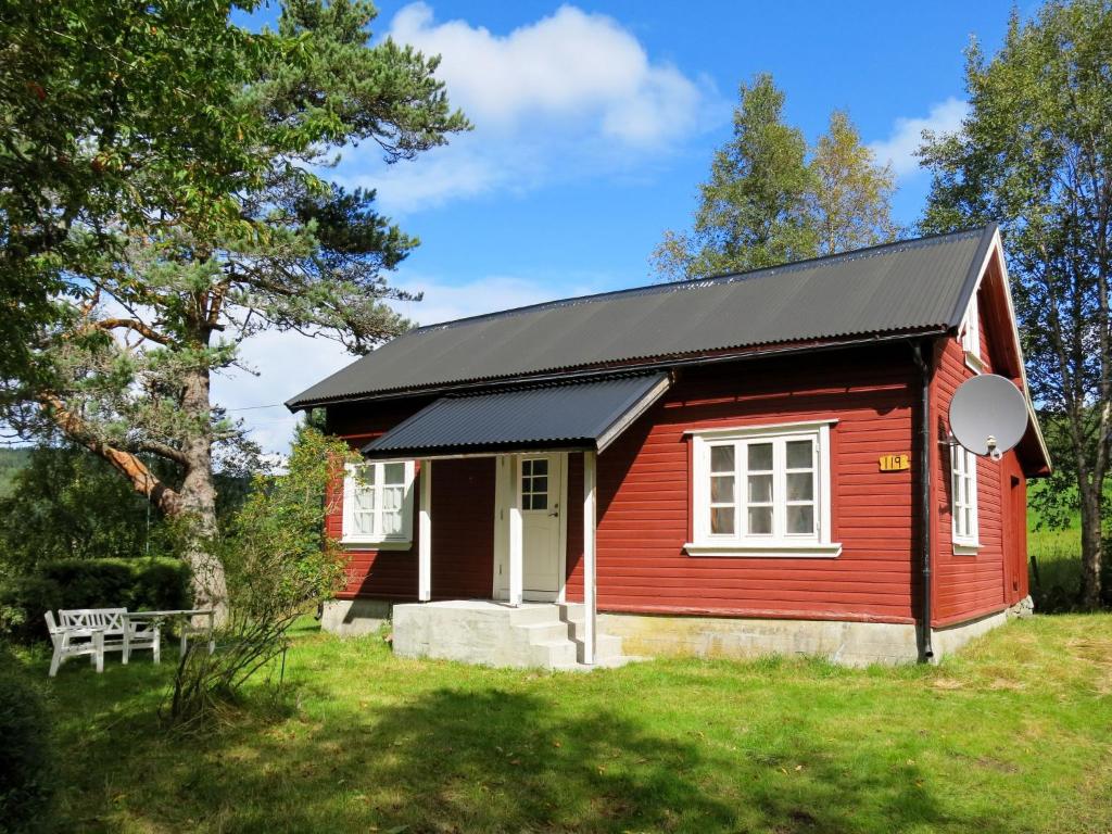 uma pequena casa vermelha com um telhado preto em Chalet Flatebygd - SOO355 by Interhome em Evje