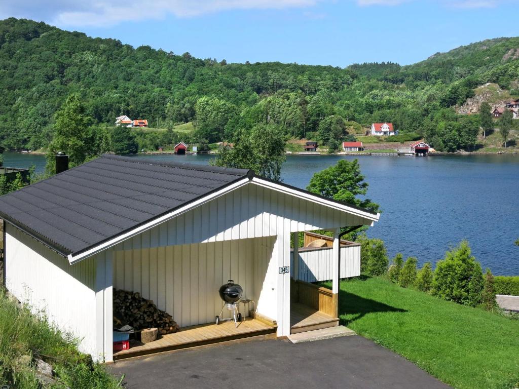 靈達爾的住宿－Holiday Home Espeøya - SOW045 by Interhome，后面有湖泊的白色车库