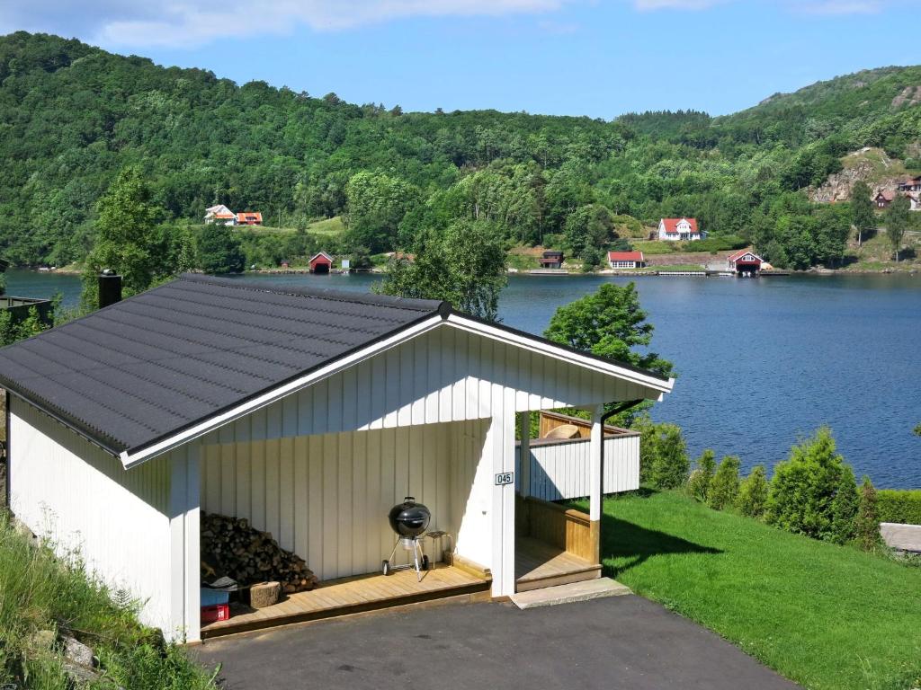 un garage bianco con un lago sullo sfondo di Holiday Home Espeøya by Interhome a Lyngdal