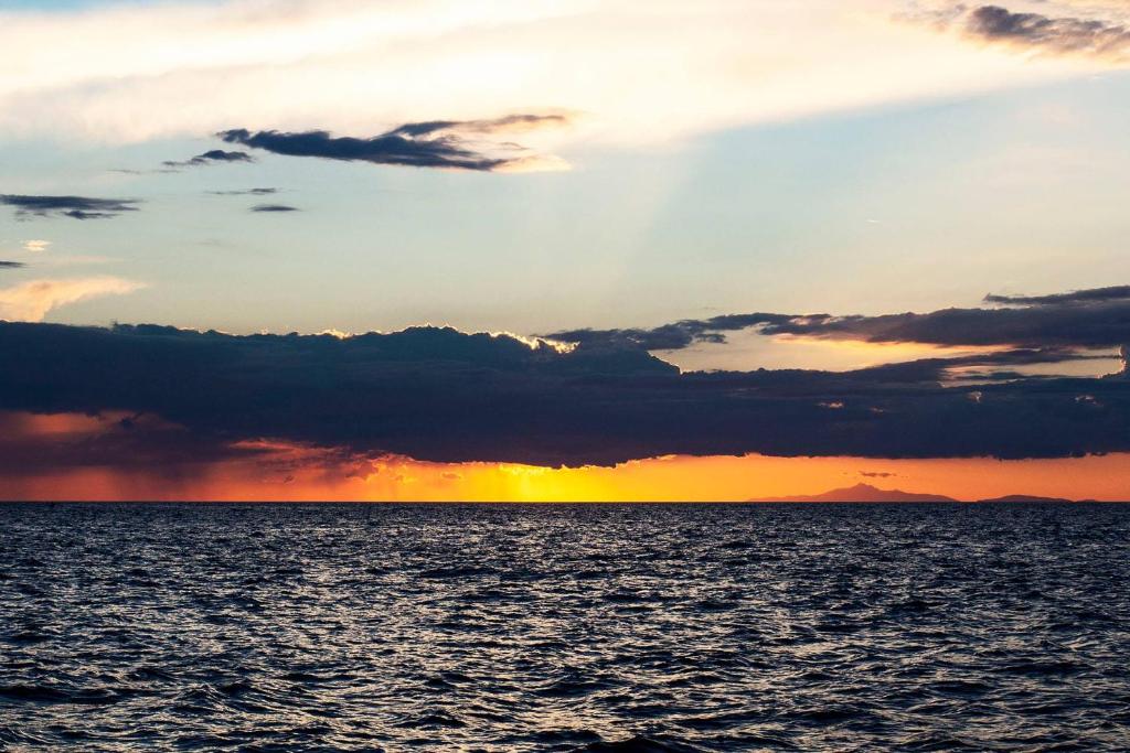 a sunset over a large body of water at Boutique Hotel Torre Di Cala Piccola in Porto Santo Stefano