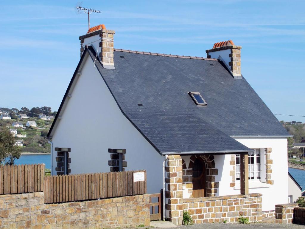a small white house with a black roof at Holiday Home Ti an Aod by Interhome in Plougasnou