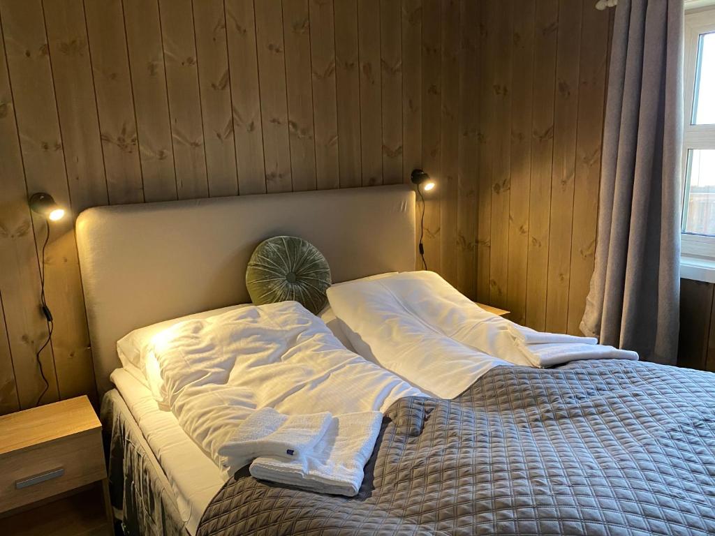 1 dormitorio con 1 cama con sábanas blancas y ventana en Korgfjellet Fjellstue as en Korgen