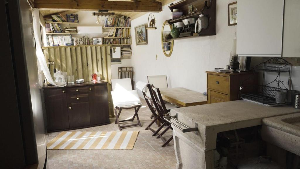 a kitchen with two chairs and a table in it at une petite maison entre vignes et mer in Saint-Côme
