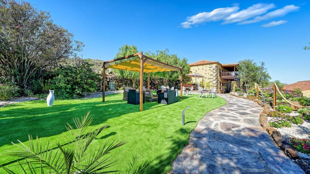 einen Garten mit einem Pavillon im Gras in der Unterkunft Hotel Rural la Correa del Almendro ONLY ADULTS in Arona