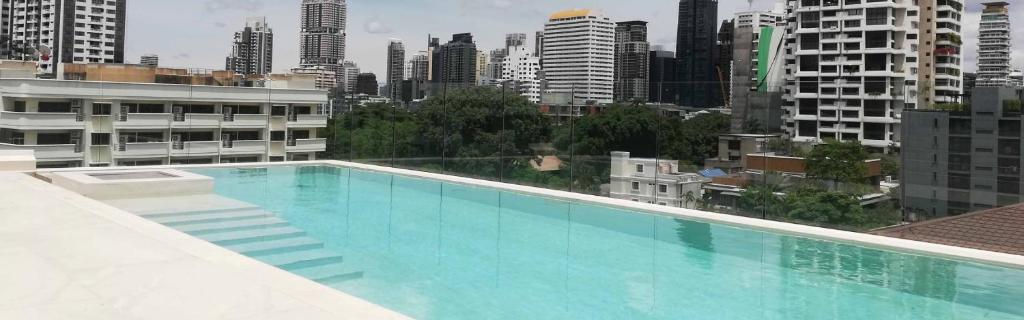 a large swimming pool on top of a building at ashley hotel bkk in Bangkok